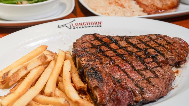 A ribeye and fries on a LongHorn Steakhouse plate