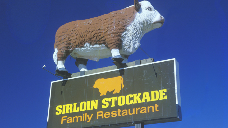 A Sirloin Stockade Sign with a cow statue above
