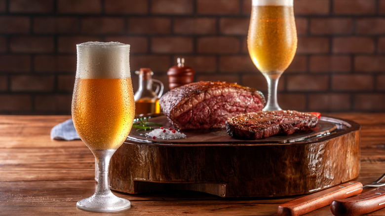A steak with two glasses of chilled beer