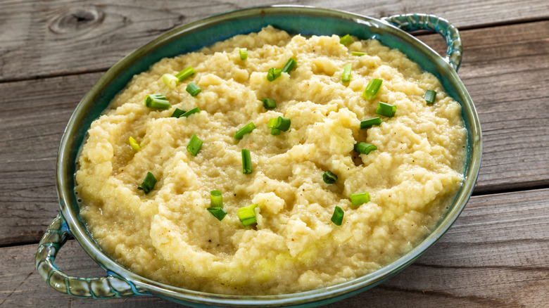 Mashed turnips garnished with chives in a ceramic blue-green dish