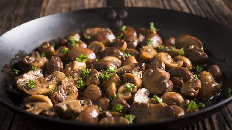 Sautéed mushrooms in a pan with herbs