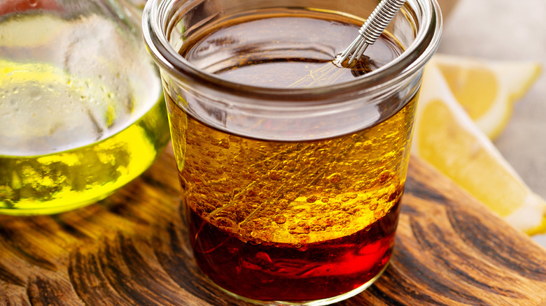 vinaigrette in a glass jar with a small whisk