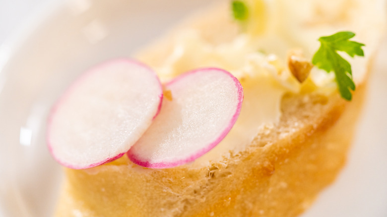 thinly slices radishes with butter on bread