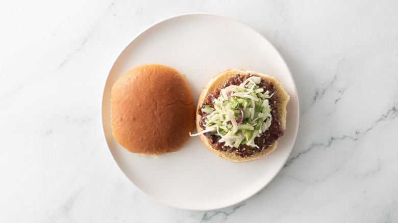 Open faced pork burger with slaw on plate