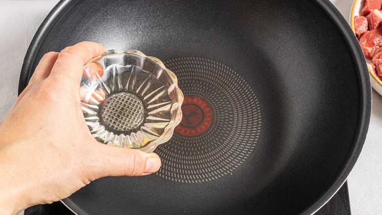 Adding oil to a wok pan