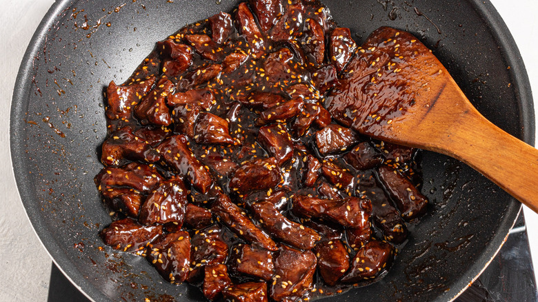 Wok with steak bites cooked in a sticky soy sauce