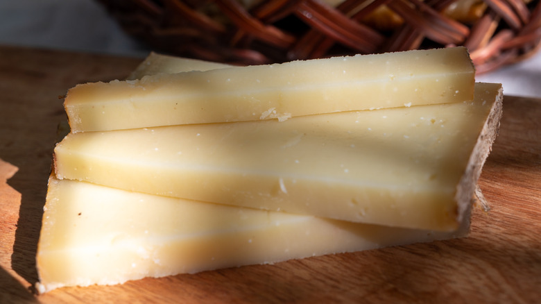 Slices of an Alpine cheese on a wooden board
