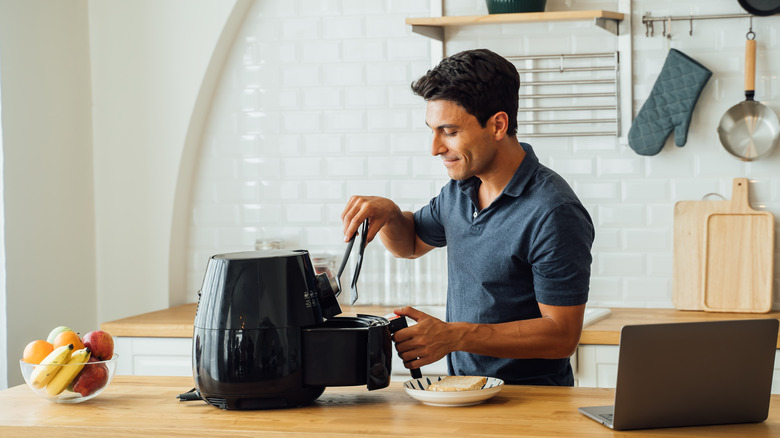 Man reaching into air fryer
