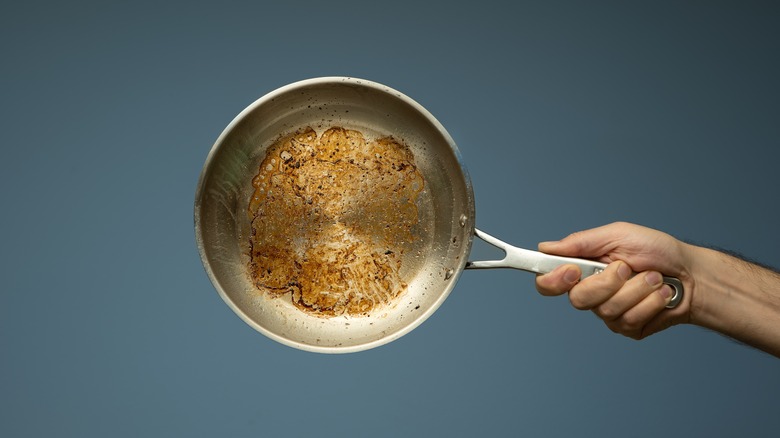 Hand holding greasy pan