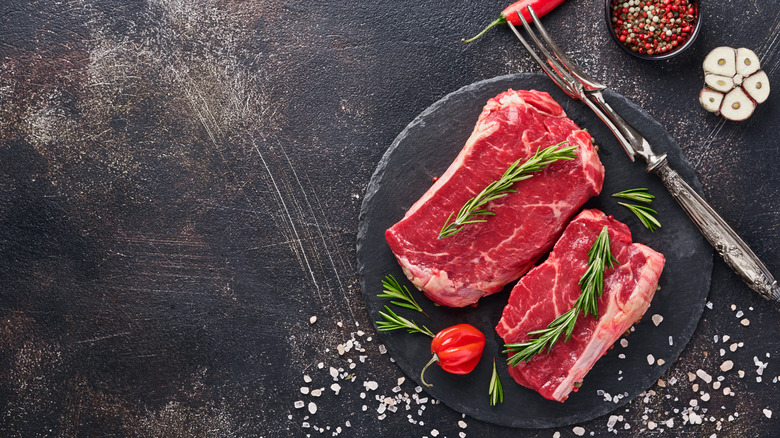 Raw steaks on platter