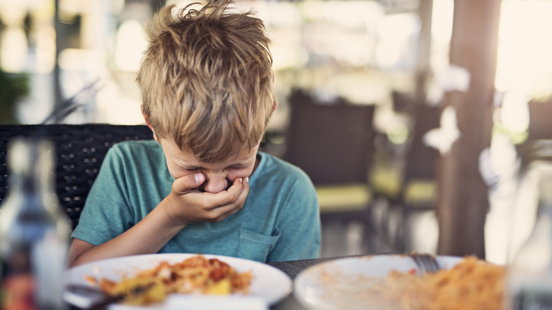 Boy getting sick at restaurant
