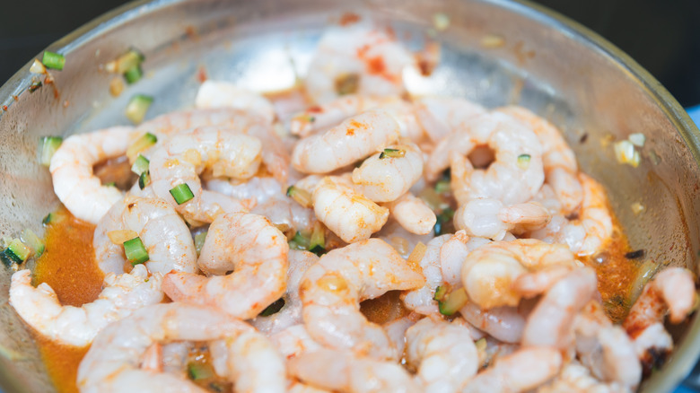 Cooking shrimp scampi in a pan.