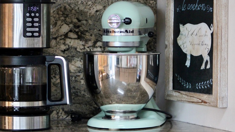 A pastel green KitchenAid stand mixer is seen on a countertop.