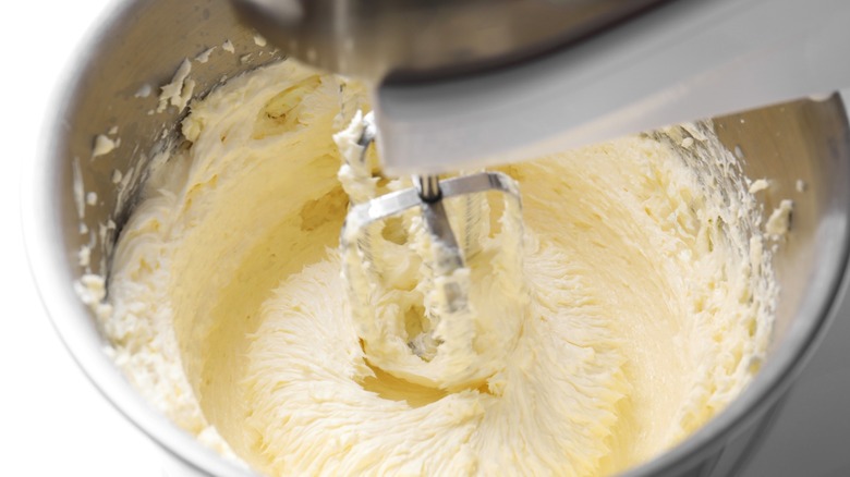 Baking tools and ingredients like a whisk and a bowl of flour are arranged around an empty space.