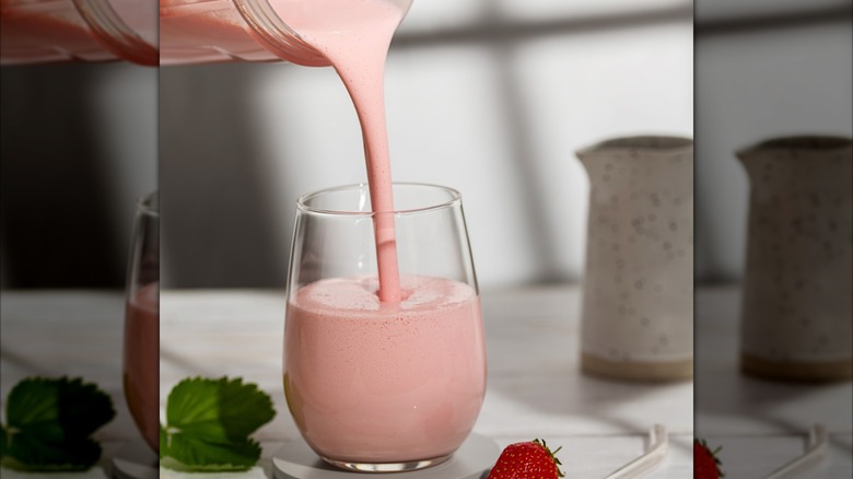 Pink drinkable yogurt being poured into a glass