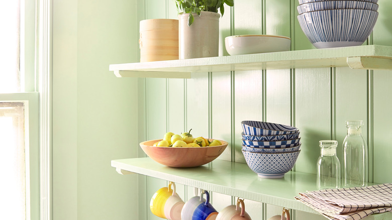 Bowls are stacked on a kitchen's open shelves.