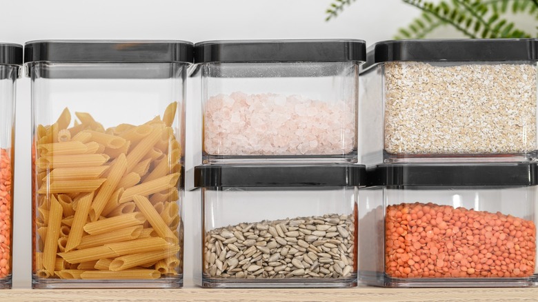Dry goods stored in clear plastic airtight containers in a food pantry