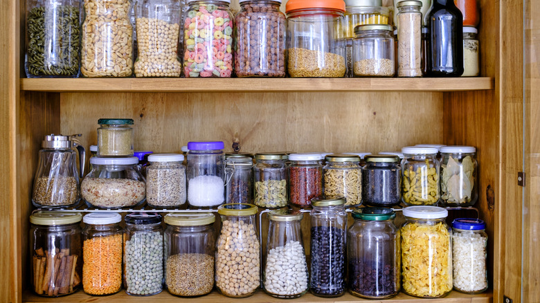 a pantry shelf full of round glass jars