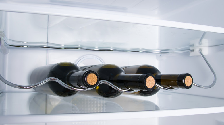Three bottles of wine on refrigerator wine rack