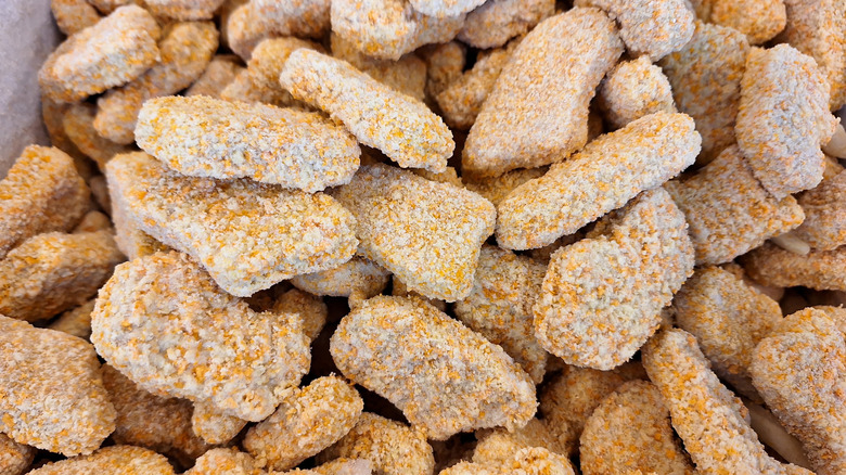 A close-up of frozen chicken nuggets piled together.