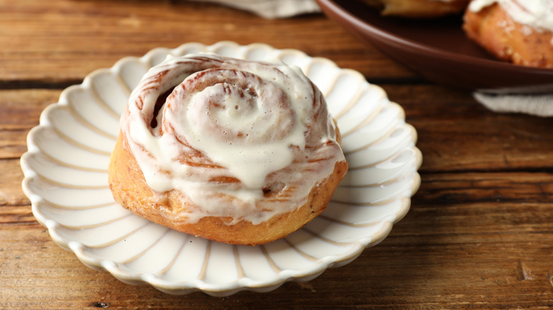 cinnamon roll served on a fluted white plate