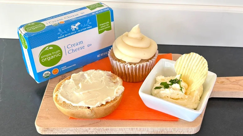 A package of Simple Truth Organic Cream Cheese with a frosted cupcake, cream cheese bagel, and bowl of dip.
