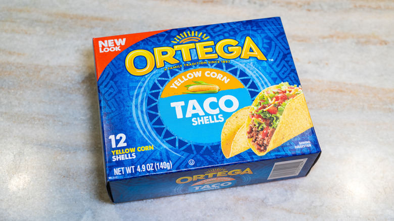 A box of Ortega yellow corn taco shells on marble background