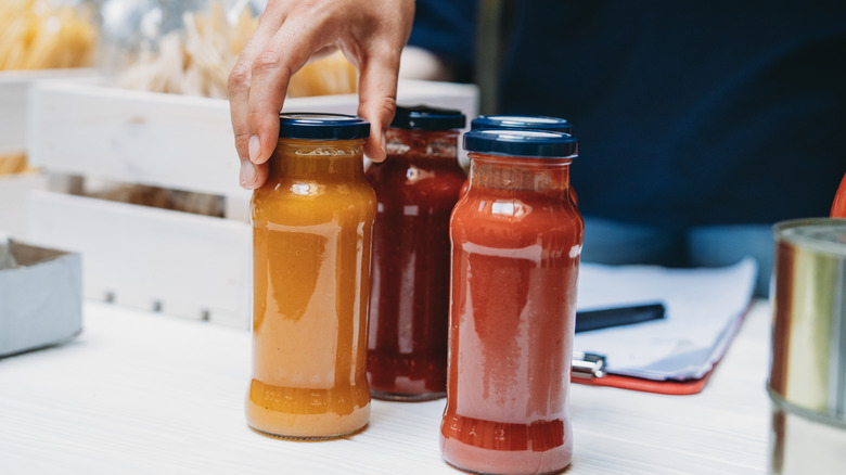 Jars of pasta sauce being handled