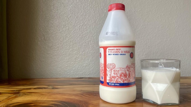 Bottle and glass of Trader Joe's Whole Milk on a wooden table
