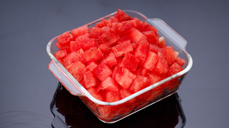 Watermelon Slices,cutpiece of watermelon arranged in a transparent square glass container with black background, isolated.