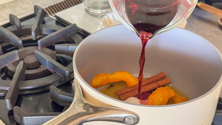 pouring red wine into pot