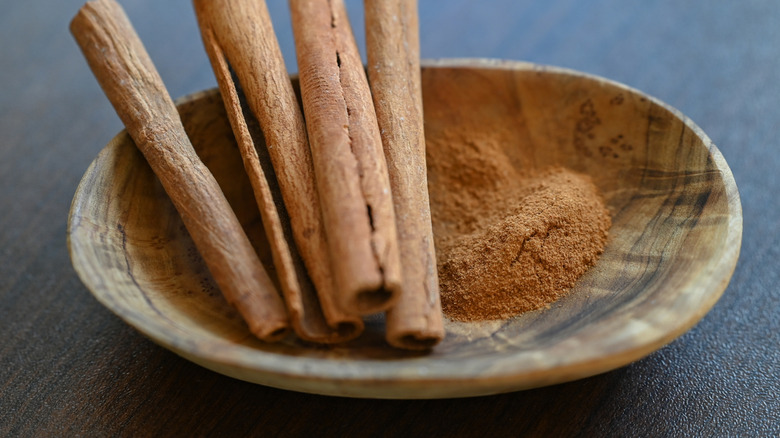Cinnamon powder, a finely ground inner bark, used for quick flavor release in desserts and drinks and cinnamon sticks - whole, curled pieces of bark used for slower infusion in stocks and stews