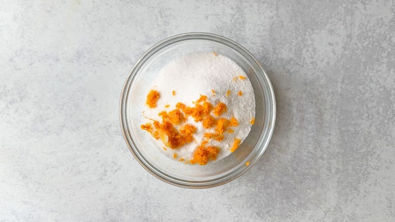 Granulated sugar and orange zest in small glass bowl