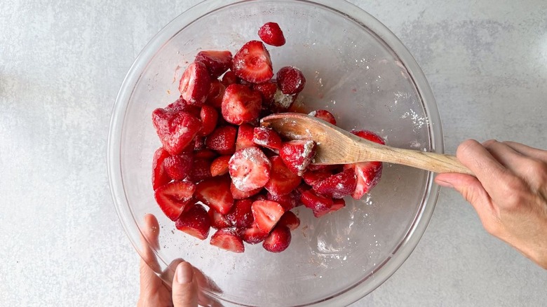 Tossing strawberry halves with cornstarch, vanilla, and cardamom