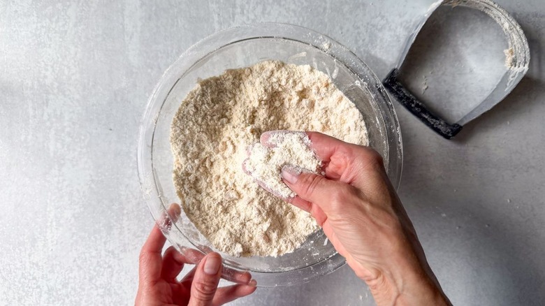 Glass bowl filled with biscuit dry ingredients and brown butter cut in