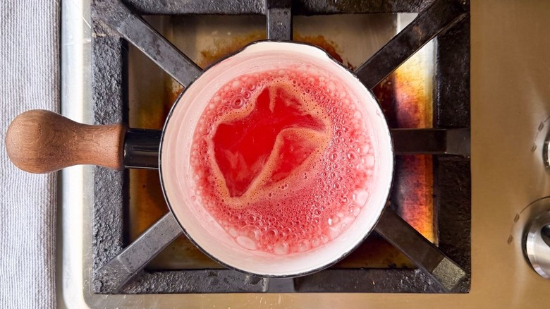 Strawberry syrup simmering in sauce pan on stovetop