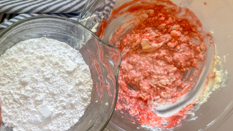 adding powdered sugar to bowl with strawberry and cream cheese mixture