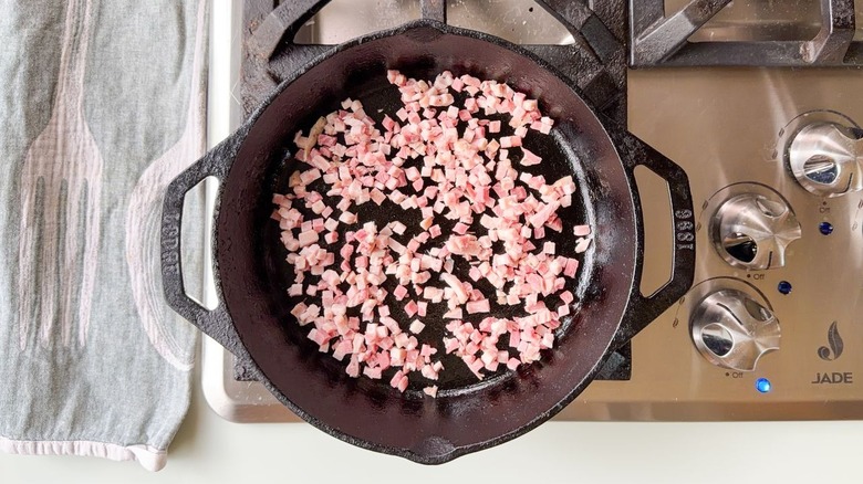 Chopped pancetta in cast iron skillet on stovetop