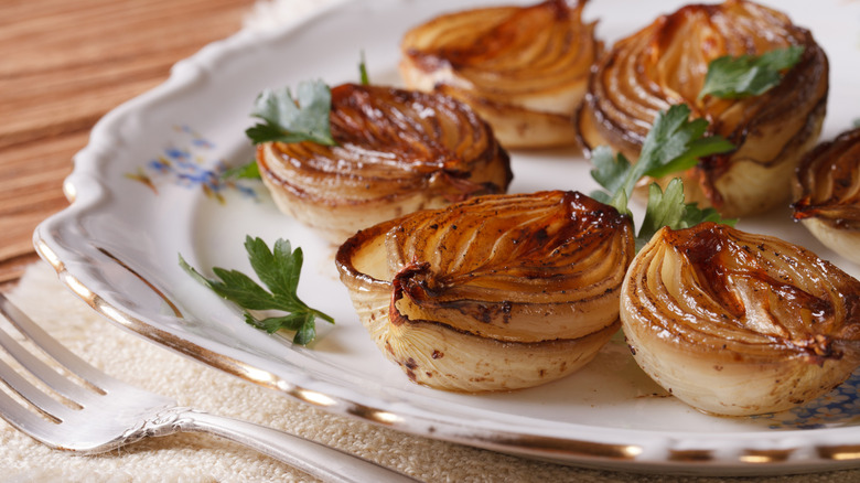 Roasted onions sit on a white plate