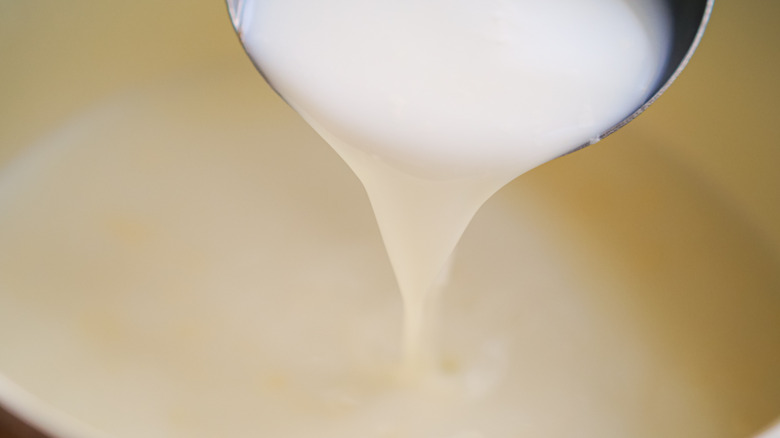 Milk pouring from a ladle.