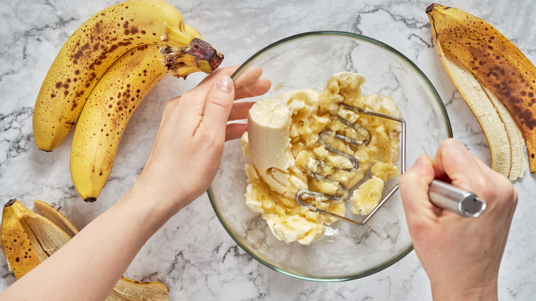 Mashing bananas in glass bowl