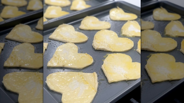 Heart sugar cookies with egg wash on a baking tray