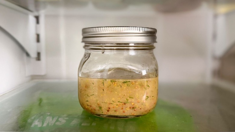 Sweet mustard dill dressing in glass jar in refrigerator