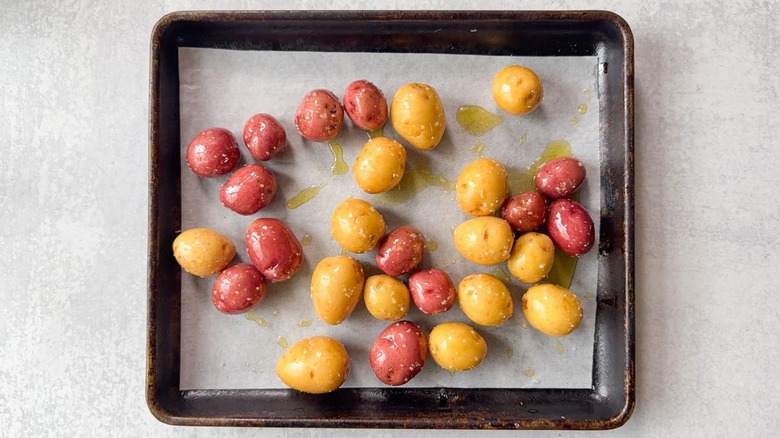 Baby red and gold potatoes on parchment-lined baking sheet