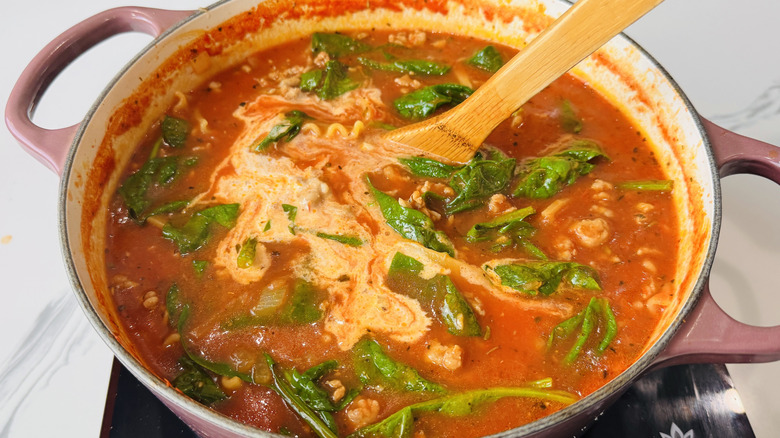 pot of tomato-noodle soup with spinach and cream