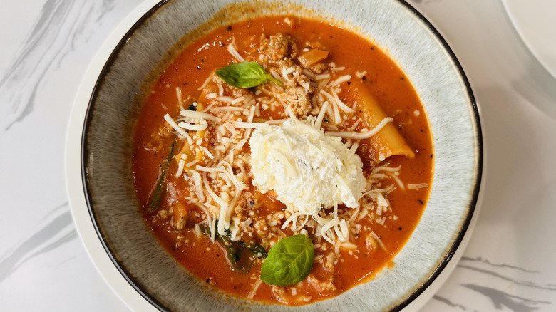 bowl of tomato-noodle soup with cheese