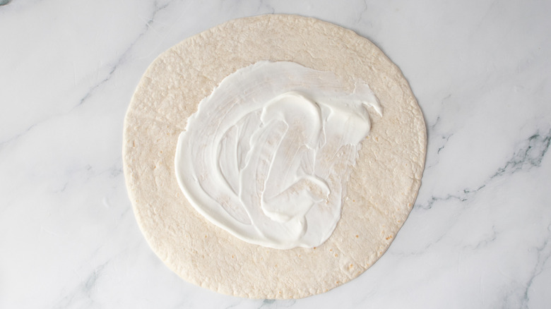 Large flour tortilla spread with sour cream
