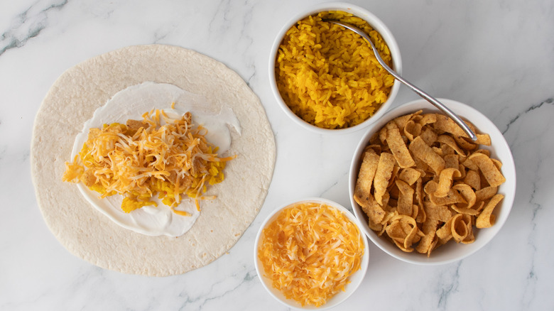 Large flour tortilla topped with rice, corn chips, and cheese