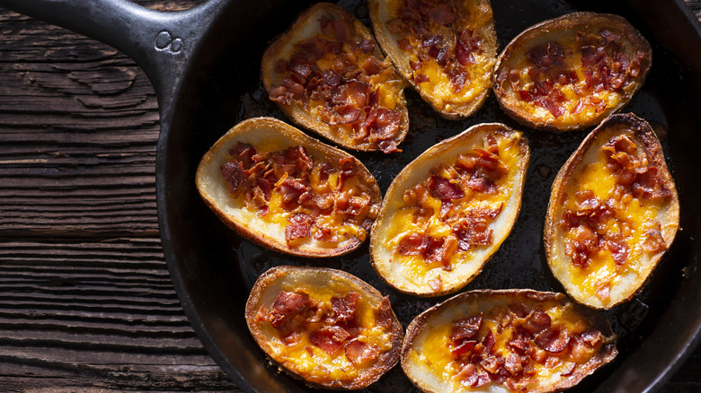Cheesy potato skins with bacon in skillet