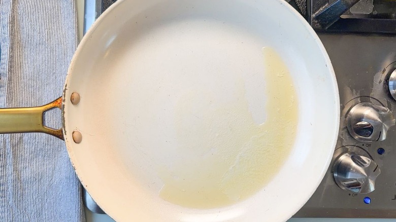 Melted butter in white skillet on stovetop